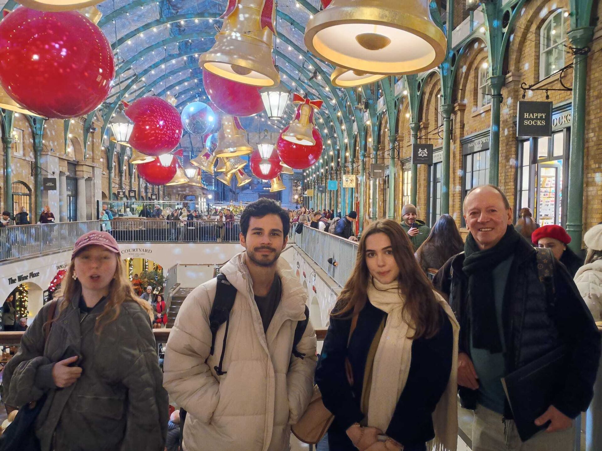 82 (lights) English students in front of London's Covent Garden's Covered Market Christmas decorations